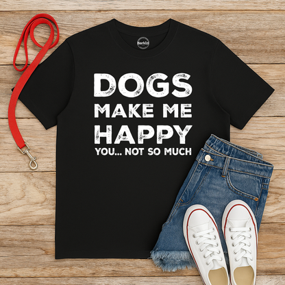 Black t-shirt with 'DOGS MAKE ME HAPPY YOU... NOT SO MUCH' text, red leash, jeans, and white sneakers on a wooden surface.