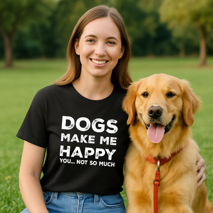 Woman wearing a black t-shirt with 'DOGS MAKE ME HAPPY YOU... NOT SO MUCH' text, standing next to a golden dog in a park.