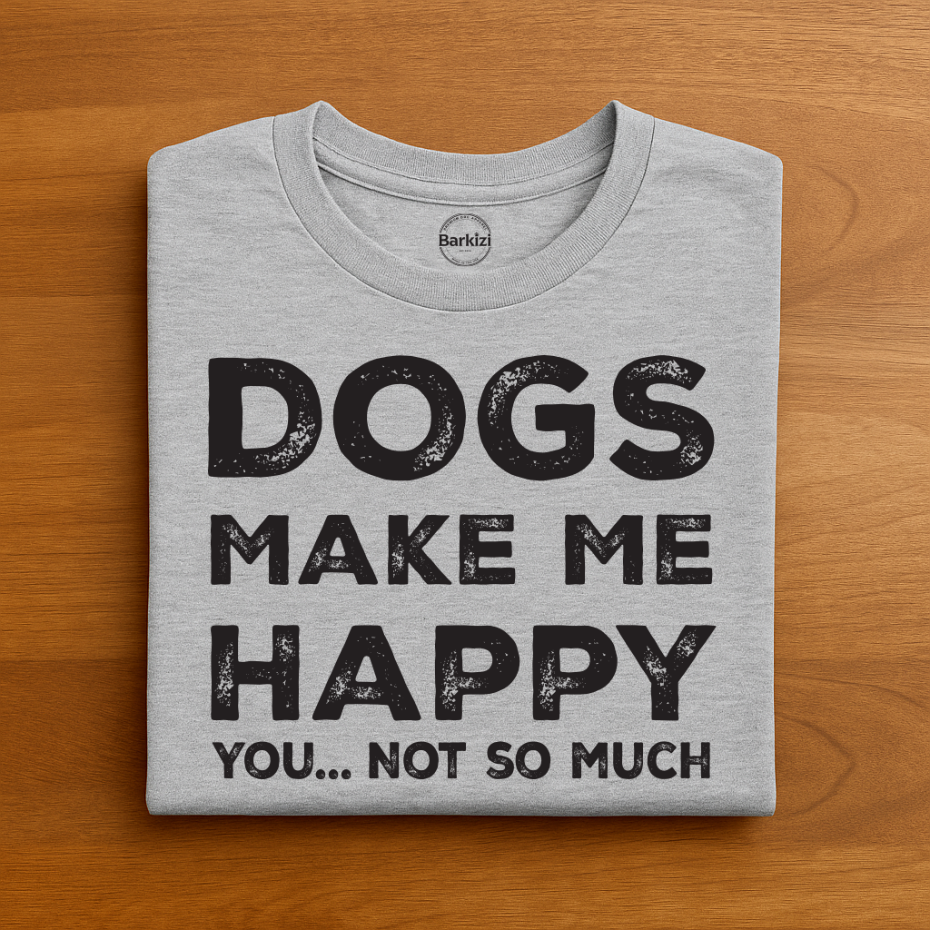 Folded gray t-shirt with 'DOGS MAKE ME HAPPY YOU... NOT SO MUCH' text on a wooden surface